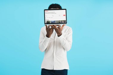 Kiev, Ukrayna - 17 Mayıs 2019: Airbnb web sitesi ile dizüstü bilgisayar gösteren Afro-Amerikan adam, mavi izole