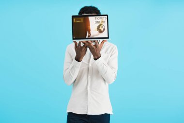 mavi izole biletleri online dizüstü bilgisayar gösteren afrikalı amerikalı adam