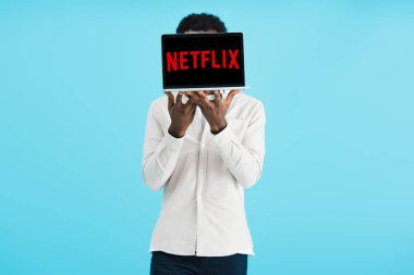 Kiev, Ukrayna - 17 Mayıs 2019: Netflix web sitesi ile dizüstü bilgisayar gösteren Afro-Amerikan adam, mavi izole