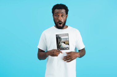 şok afro-amerikan adam bilet uygulaması ile dijital tablet gösteren, mavi izole