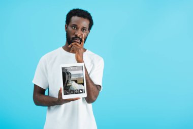 düşünceli afro-amerikan adam bilet uygulaması ile dijital tablet gösteren, mavi izole