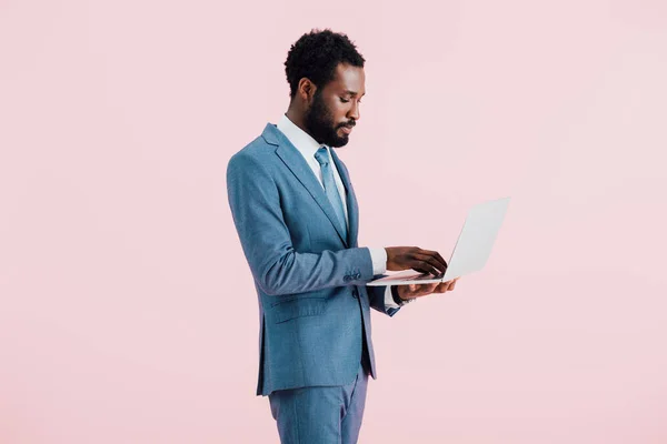 ピンクで隔離されたラップトップを使用してアフリカ系アメリカ人のビジネスマン — ストック写真