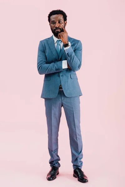 ピンクに孤立したスーツを着た思慮深いアフリカ系アメリカ人ビジネスマン — ストック写真