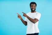 cheerful african american man pointing isolated on blue