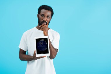 Kiev, Ukrayna - 17 Mayıs 2019: düşünceli afro-amerikan adam dijital tablet gösteren, mavi izole