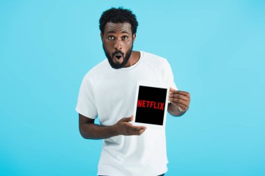 Kiev, Ukrayna - 17 Mayıs 2019: netflix uygulaması ile dijital tablet gösteren afro-amerikan adam şaşırttı, mavi izole