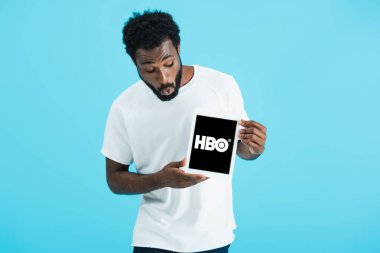 Kiev, Ukrayna - 17 Mayıs 2019: hbo uygulaması ile dijital tablet bakarak şok Afrikalı Amerikalı adam, mavi izole