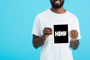 Kiev, Ukrayna - 17 Mayıs 2019: hbo uygulaması ile dijital tablet gösteren Afrikalı Amerikalı adamın kırpılmış görünümü, mavi izole