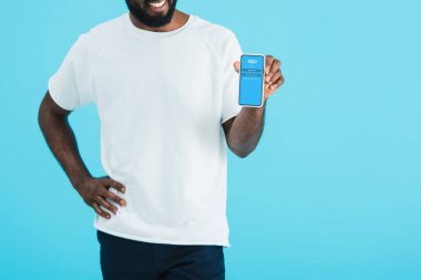 Kiev, Ukrayna - 17 Mayıs 2019: mavi izole skype uygulaması ile akıllı telefon gösteren Afrikalı Amerikalı adam kırpılmış görünümü