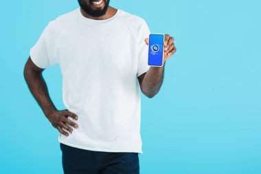 Kiev, Ukrayna - 17 Mayıs 2019: shazam uygulaması ile akıllı telefon gösteren Afrikalı Amerikalı adamın kırpılmış görünümü, mavi izole