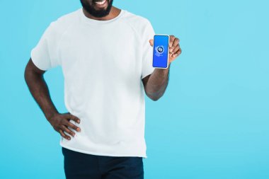 Kiev, Ukrayna - 17 Mayıs 2019: shazam uygulaması ile akıllı telefon gösteren Afrikalı Amerikalı adamın kırpılmış görünümü, mavi izole