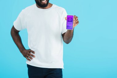 alışveriş uygulaması ile akıllı telefon gösteren Afrikalı-Amerikalı adam kırpılmış görünümü, mavi izole