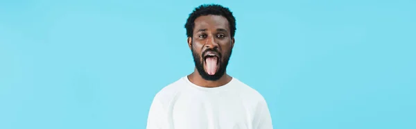 アフリカ系アメリカ人男性が青色で孤立した舌を突き出す — ストック写真