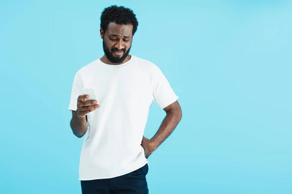 Verward Afro Amerikaanse Man Met Behulp Van Smartphone Geïsoleerd Blauw — Stockfoto