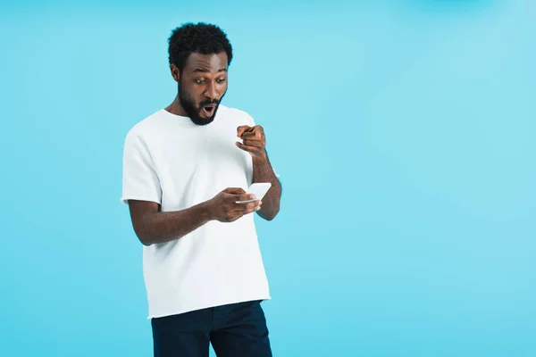 Förvånad Afrikansk Amerikansk Man Med Smartphone Isolerad Blå — Stockfoto