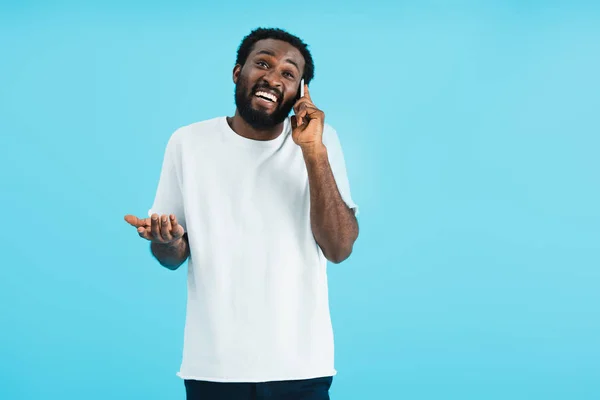 スマートフォンで話すシュラッグジェスチャーを持つアフリカ系アメリカ人男性 青で孤立 — ストック写真