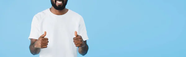青で孤立した親指を示す幸せなアフリカ系アメリカ人男性のトリミングされたビュー — ストック写真