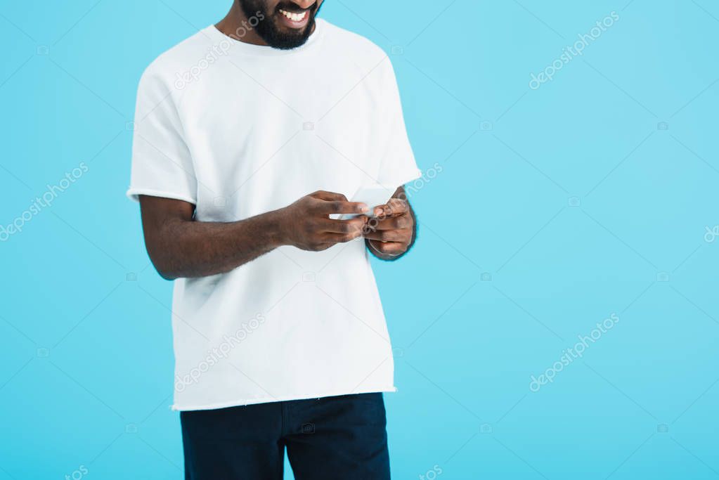 cropped view of african american man talking on smartphone, isolated on blue