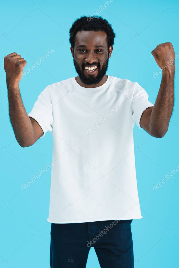 excited handsome african american man gesturing isolated on blue