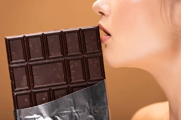 Bej Izole Dudakları Yakınında Folyo Çikolata Tutan Güzel Genç Kadın — Stok fotoğraf