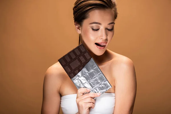 Gümüş Folyo Çikolata Tutan Güzel Memnun Genç Kadın Bej Izole — Stok fotoğraf