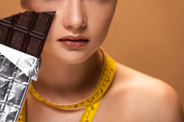Bej Izole Çikolata Çubuğu Tutan Sarı Ölçüm Bandı Ile Çıplak — Stok fotoğraf