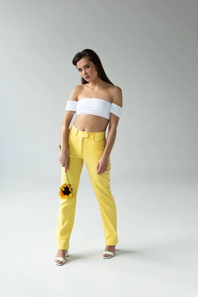Hermosa Mujer Pantalones Amarillos Top Blanco Posando Con Girasol Aislado — Foto de Stock