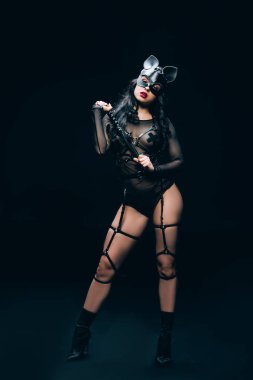 siyah arka plan üzerinde kırbaç kırbaç kırbaç ile bdsm kostüm ve maske tutkulu sıcak esmer kadın