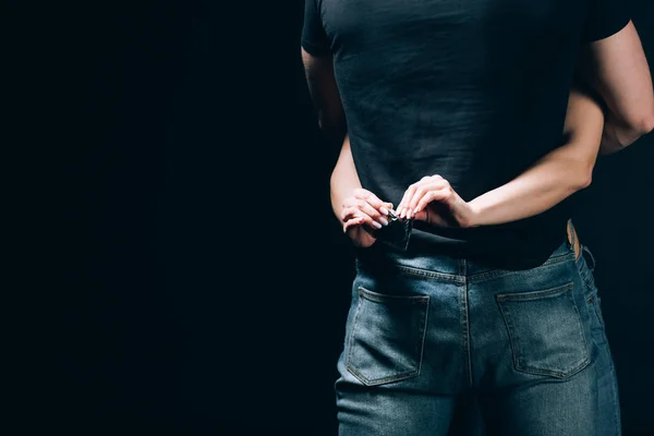 Vista Posterior Mujer Abrazando Hombre Jeans Abriendo Condón Aislado Negro — Foto de Stock