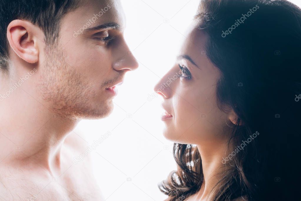 naked young couple looking at each other isolated on white