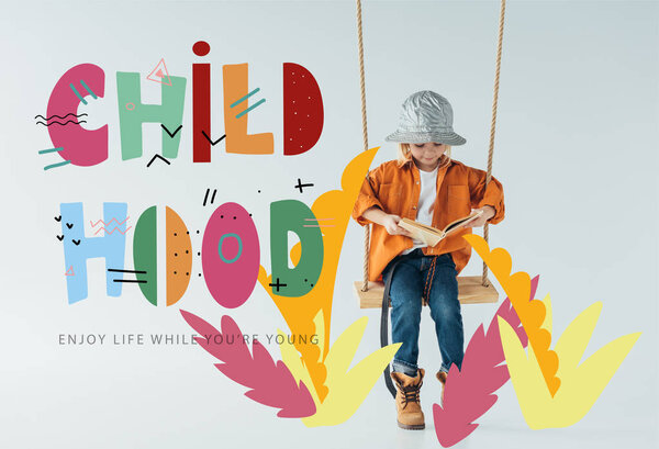 милый ребенок в джинсах и оранжевой рубашке сидит на качелях и читает книгу на сером фоне с детской иллюстрацией
