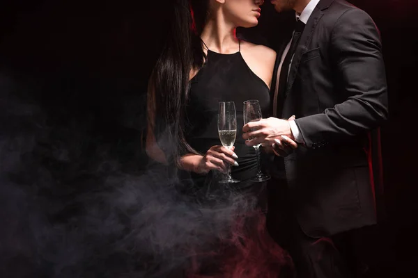裁剪视图的时尚夫妇与玻璃香槟上的黑色 — 图库照片