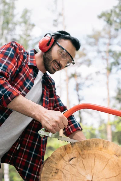 Madeireiro Alegre Óculos Proteção Auriculares Cortando Tronco Árvore Com Serra — Fotografia de Stock