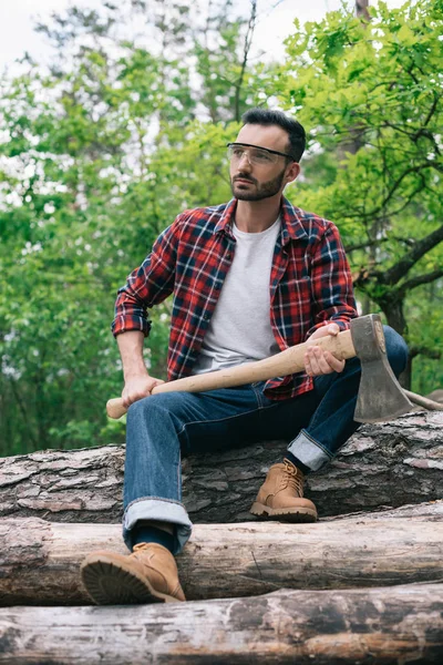 Thoughtful Lumberman Holding While Sitting Tree Trunks Forest Looking Away — Stock Photo, Image