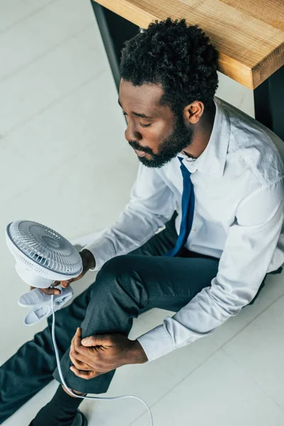 Vista Aérea Del Hombre Negocios Afroamericano Sentado Suelo Con Ventilador —  Fotos de Stock