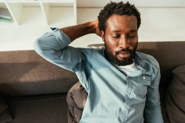 terli gömlek li bitkin Afro-Amerikan adam kanepede oturan ve kapalı gözleri ile ısı muzdarip