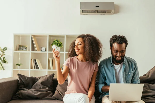 Mosolygós Afro Amerikai Ember Használ Laptopot Ülve Kanapén Közelében Vidám — Stock Fotó