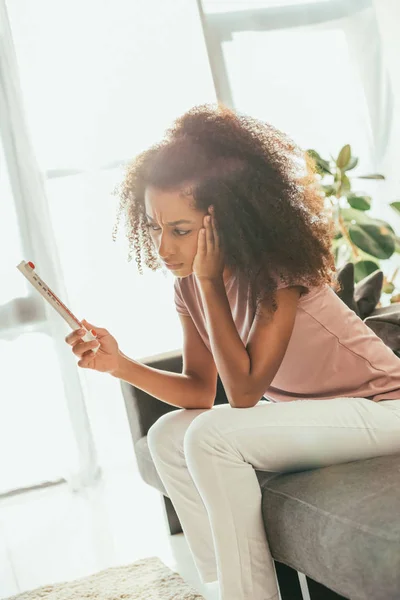 Mujer Afroamericana Insatisfecha Mirando Termómetro Mientras Está Sentada Sofá Sufriendo — Foto de Stock