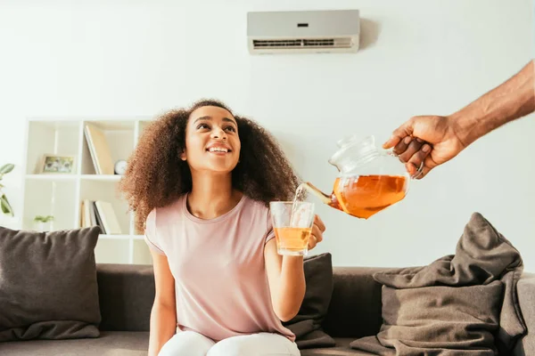 Vista Recortada Del Hombre Afroamericano Vertiendo Taza Mano Sonriente Mujer —  Fotos de Stock