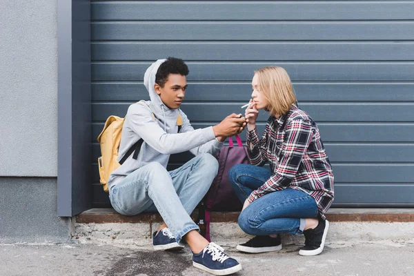 African American Boy Verlichting Sigaret Van Blonde Mooie Tiener — Stockfoto
