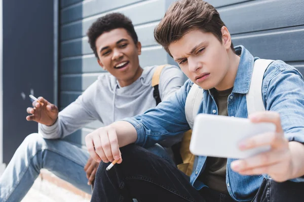 Enfoque Selectivo Amigos Sonriendo Fumando Cigarrillos Sosteniendo Cerveza Tomando Selfie — Foto de Stock