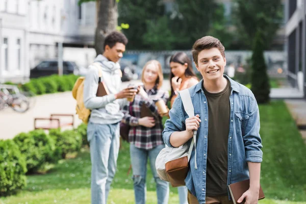 Lächelnder Teenager Mit Buch Und Rucksack Und Blick Die Kamera — Stockfoto