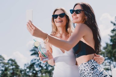 selfie çekerken mayo mutlu esmer ve sarışın kadınların düşük açı görünümü