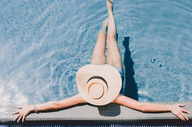 yüzme havuzunda dinlenen hasır şapka genç kadının havai görünümü