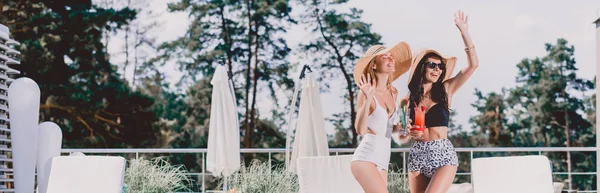 Panoramic Shot Two Pretty Girls Waving Hands Holding Cocktails — Stock Photo, Image