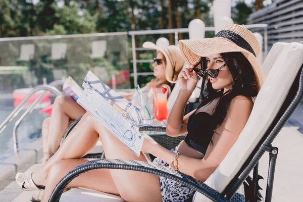 Selektiv Fokus Brunette Kvinna Läsa Journal Medan Sola Nära Vän — Stockfoto