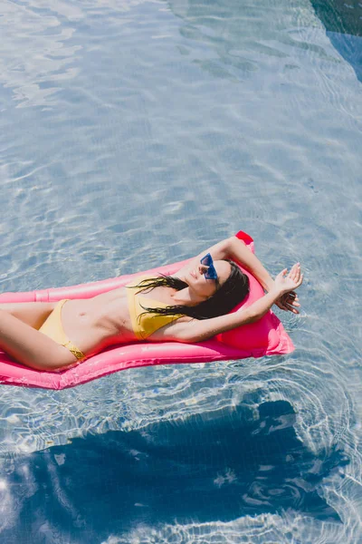 快乐黑发女人在太阳镜游泳池浮游游泳池 — 图库照片