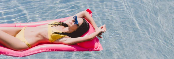スイミングプールでプールフロートで泳ぐ幸せなブルネットの女性 — ストック写真