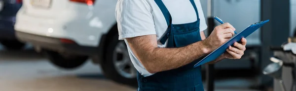 Panoramic Shot Car Mechanic Writing While Holding Clipboard Car — Stock Photo, Image