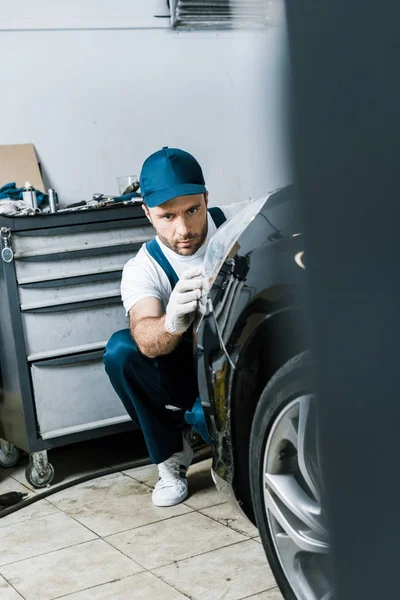 Selektivní Zaměření Vousatého Automechanika Pohledem Zadní Světlo Černém Autě — Stock fotografie